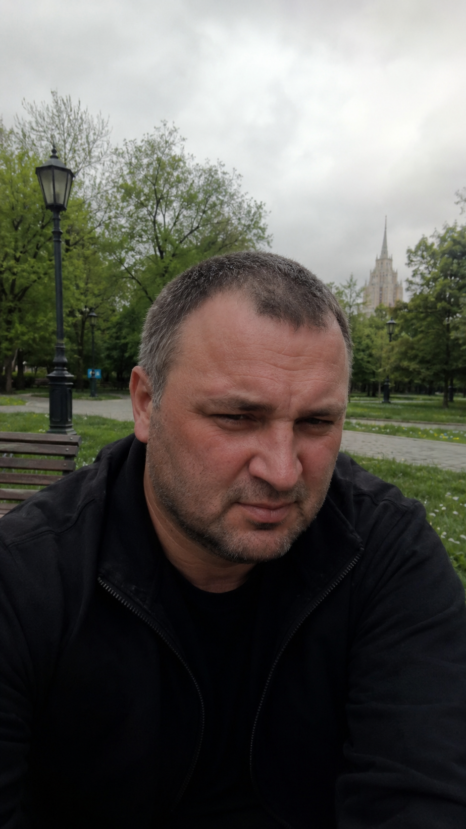 Уставший человек сидит в московском парке и думает о налогах и выживании
